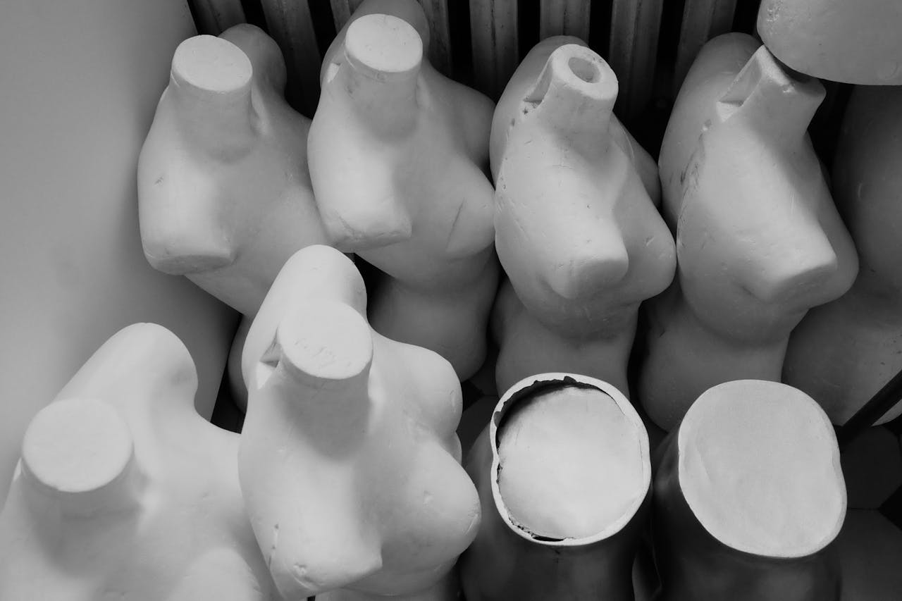 Monochrome image of multiple headless mannequin torsos arranged indoors.